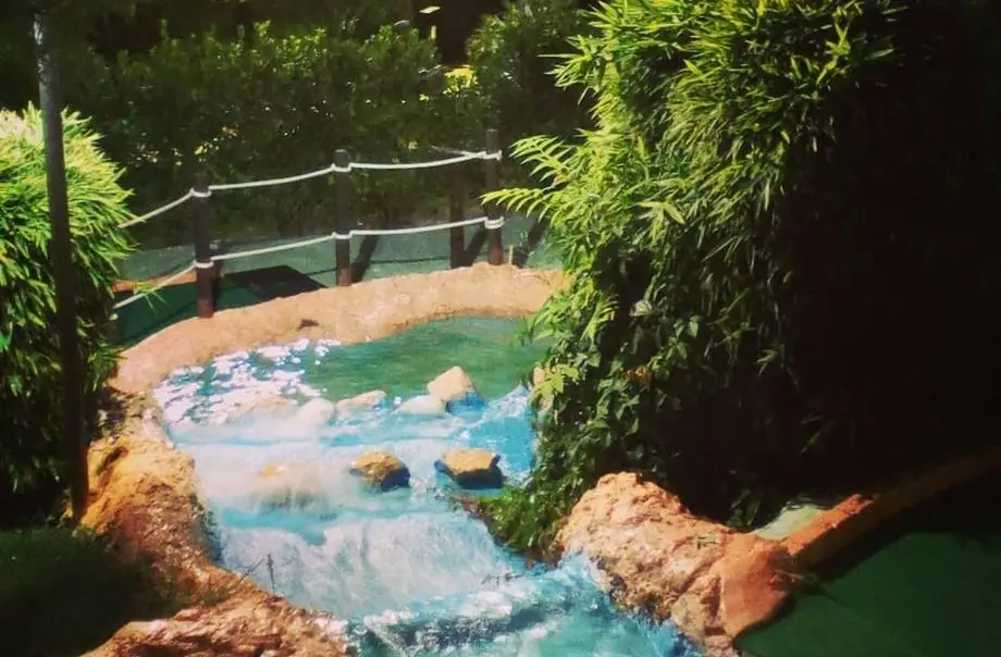 Un ruisseau avec de petites cascades entre rochers et bambous le long du parcours Indiana Golf