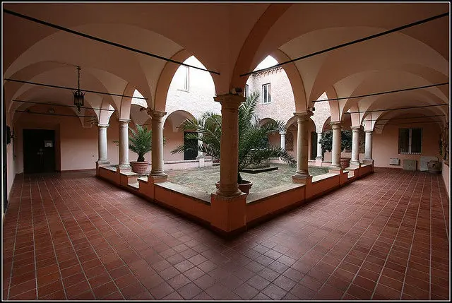 Il chiostro del Santuario delle Grazie a Covignano, con il portico ad archi su colonne e le palme nel giardino al centro