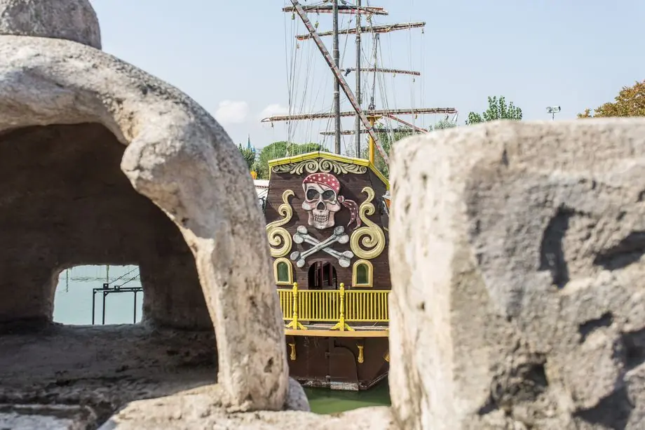 An artificial cave with a pirate ship visible in the background at Fiabilandia