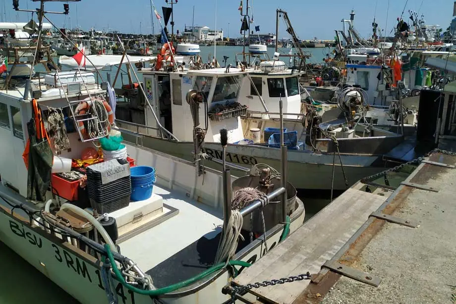 Am Kai im Hafen von Cattolica liegende Fischereiboote mit Netzen und Ausrüstung an Deck
