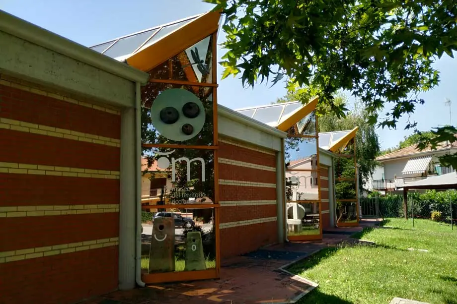 Le Centro Culturale della Pesa à Riccione : façade en brique avec baies vitrées orange et logo du Museo del Territorio