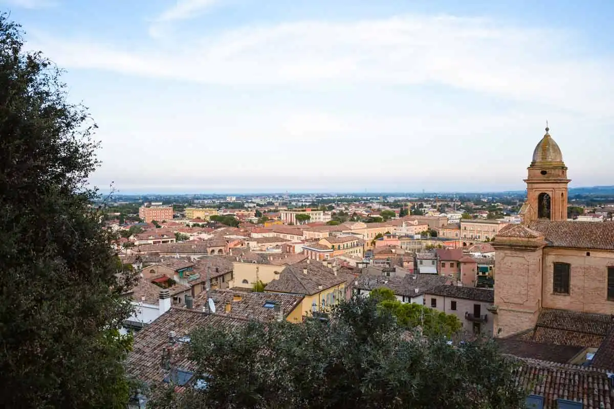 I tetti di Santarcangelo di Romagna visti dall'alto, con un campanile a cupola sulla destra e la pianura fino all'orizzonte