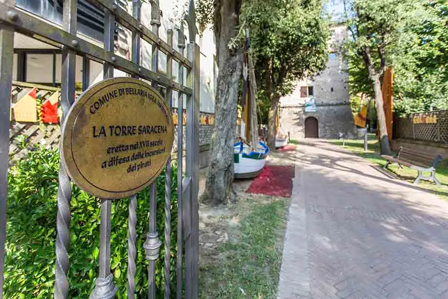 The Comune plaque on the Torre Saracena gate and, at the end of the garden path, the tower with a boat and sails