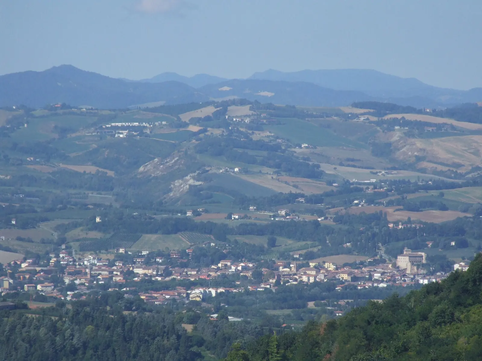 The Romagna valley seen from the Bertinoro hills, with a town on the plain and mountains in the background