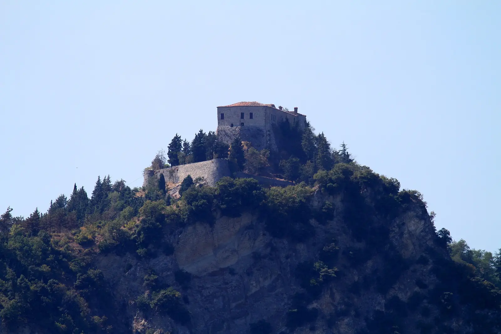 Il Castello di Montebello in cima allo sperone di roccia, circondato dalla vegetazione