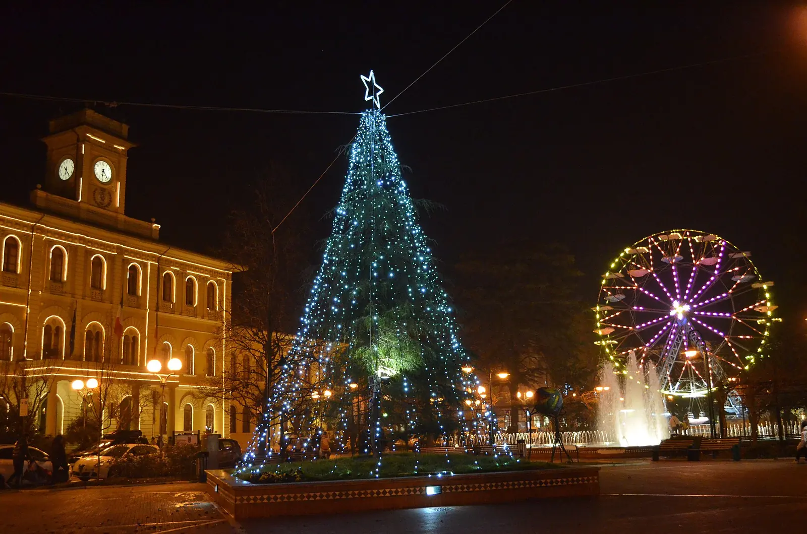 L'albero di Natale illuminato davanti al municipio di Cattolica, con una ruota panoramica accesa sulla destra