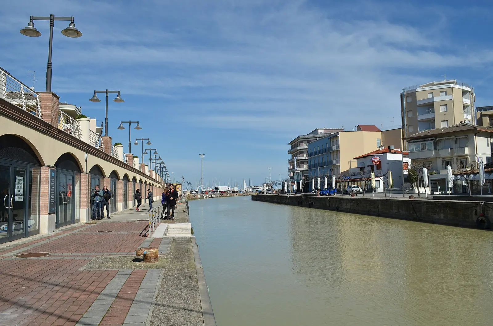 La banchina in mattoni del porto canale di Cattolica, con i portici a sinistra e le case sul lato opposto