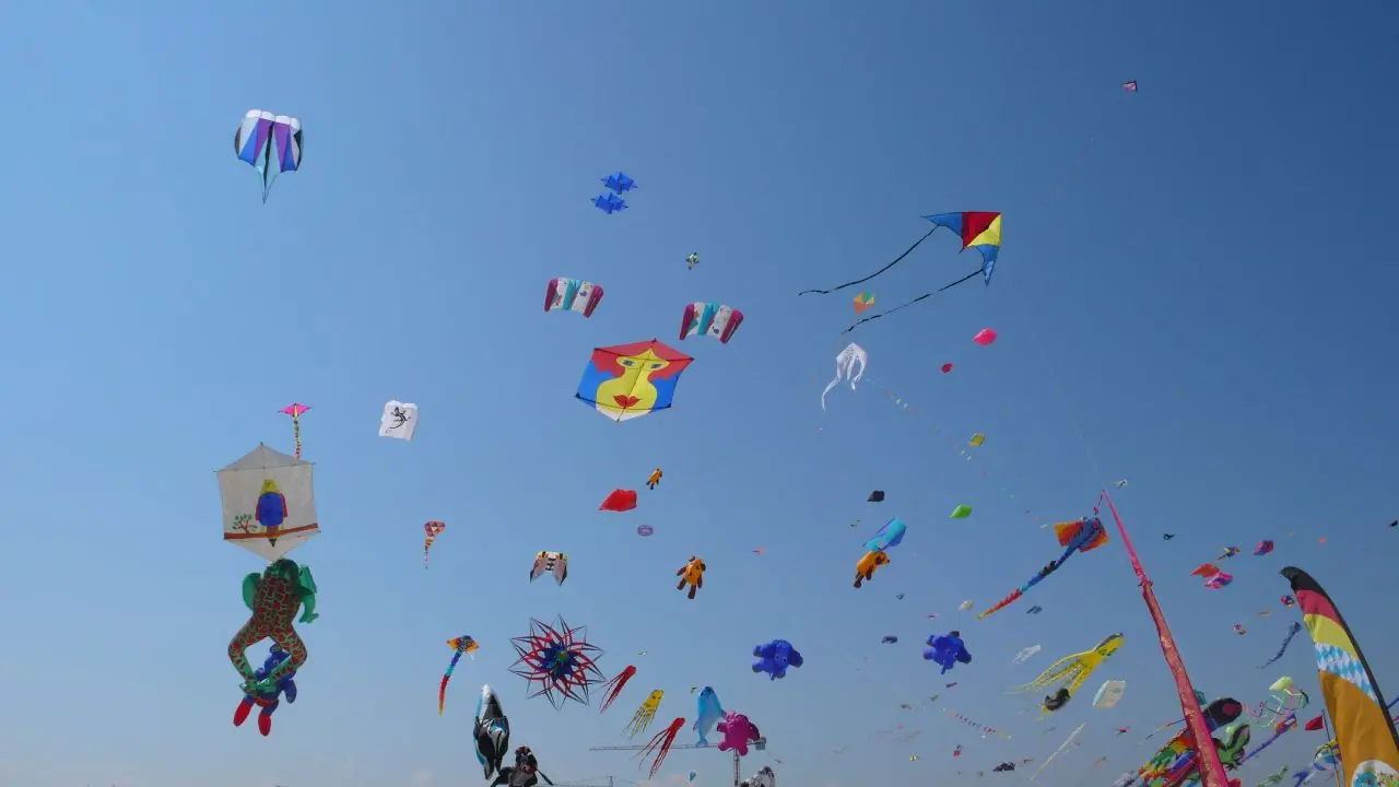 Dutzende Drachen in verschiedenen Formen und Farben am blauen Himmel über Cervia