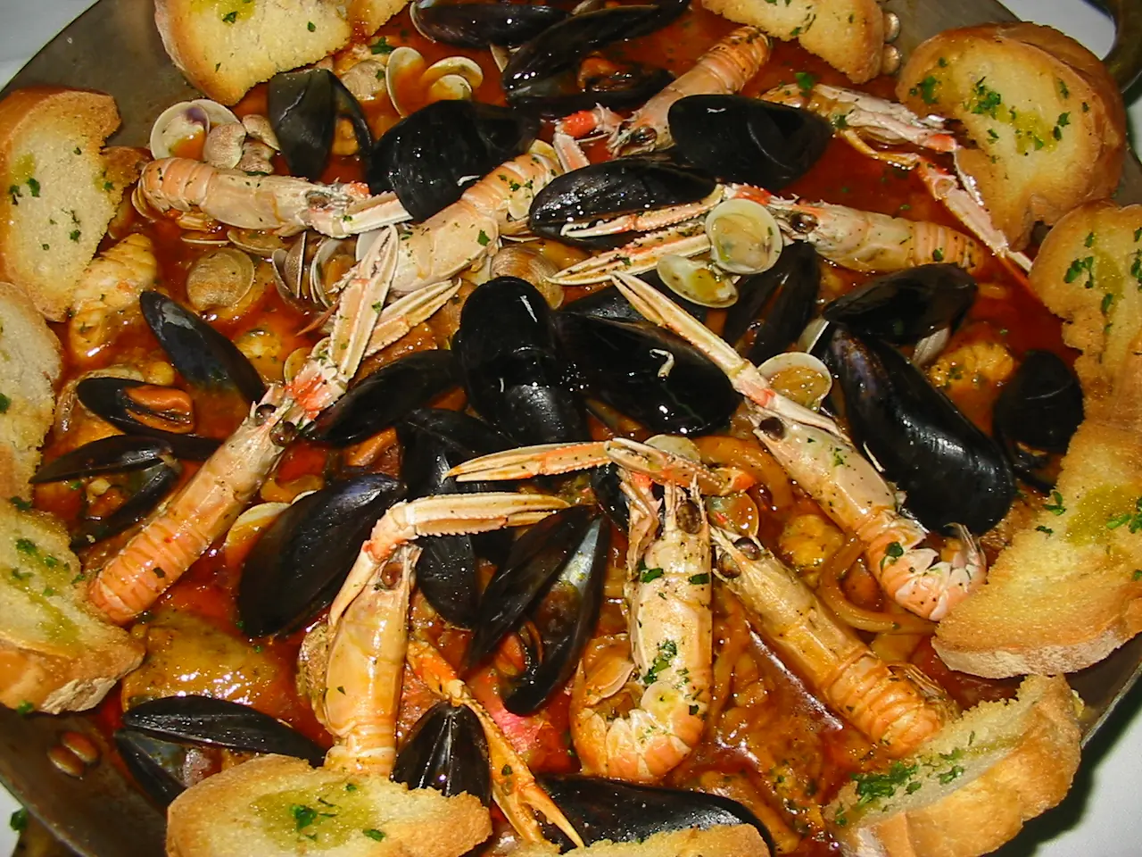 Fisch-Brodetto mit Miesmuscheln, Kaisergranaten, Venusmuscheln und geröstetem Brot in einer Form