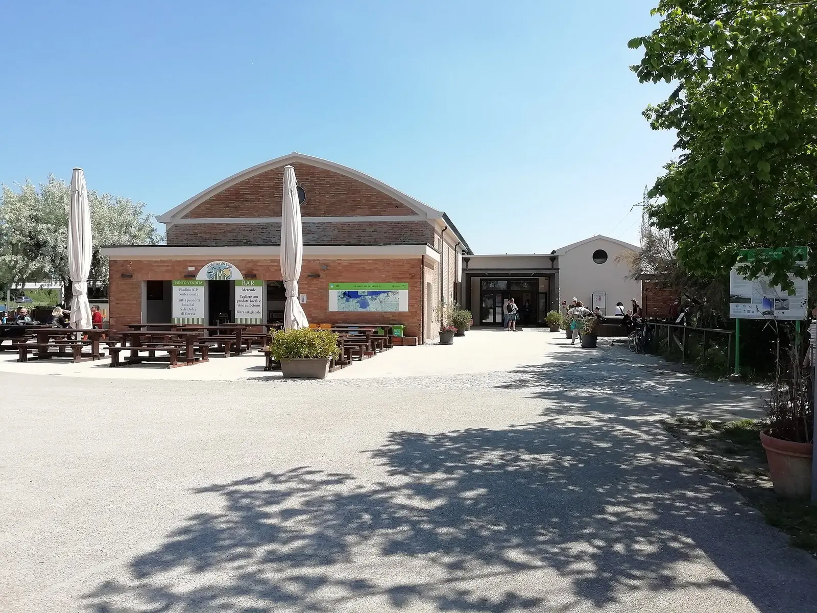 The Centro visite della Salina di Cervia building, with outdoor tables and an information sign on the right