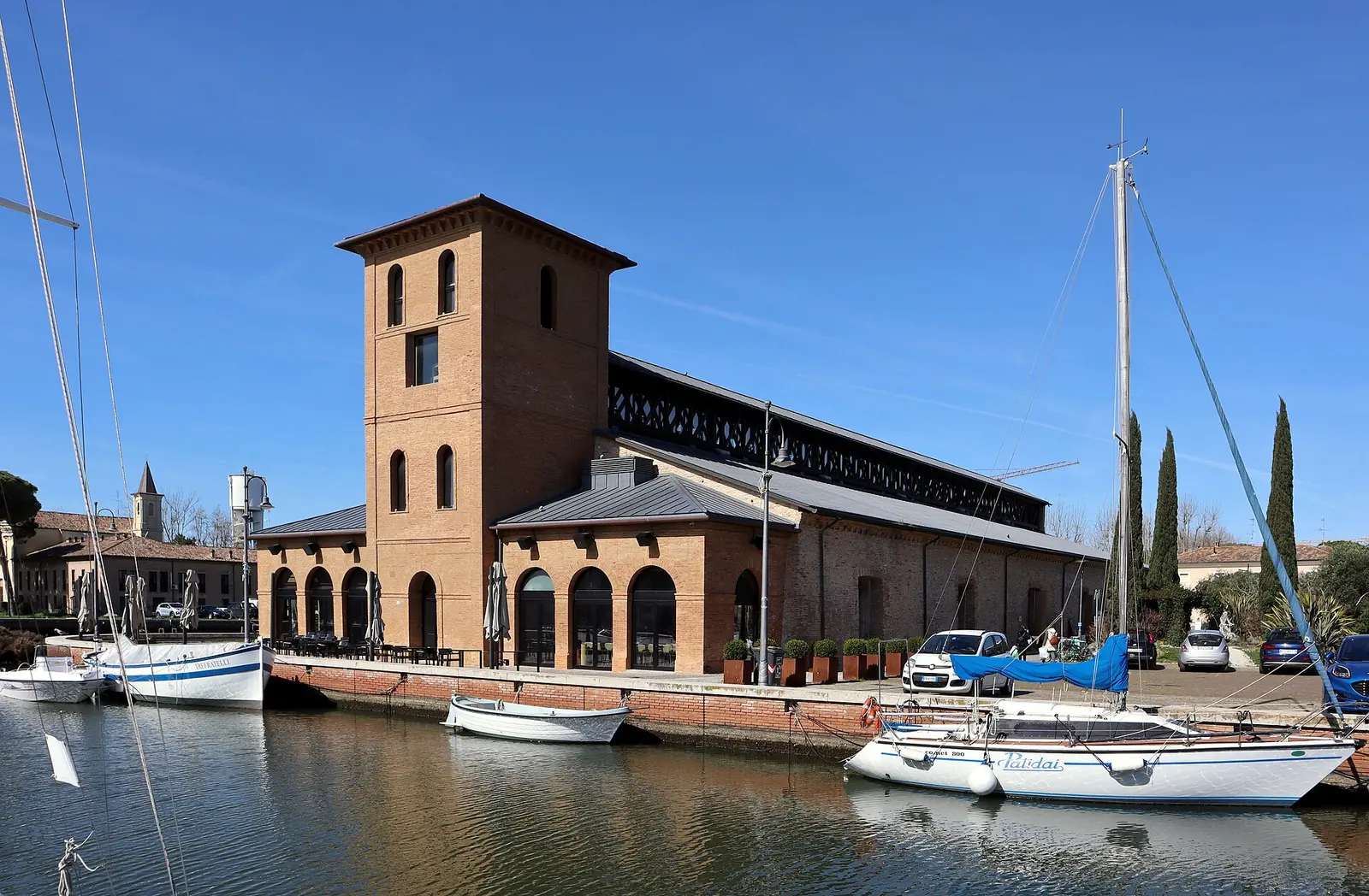 Il magazzino del sale della darsena di Cervia, edificio in mattoni con torre, affacciato sul canale con le barche