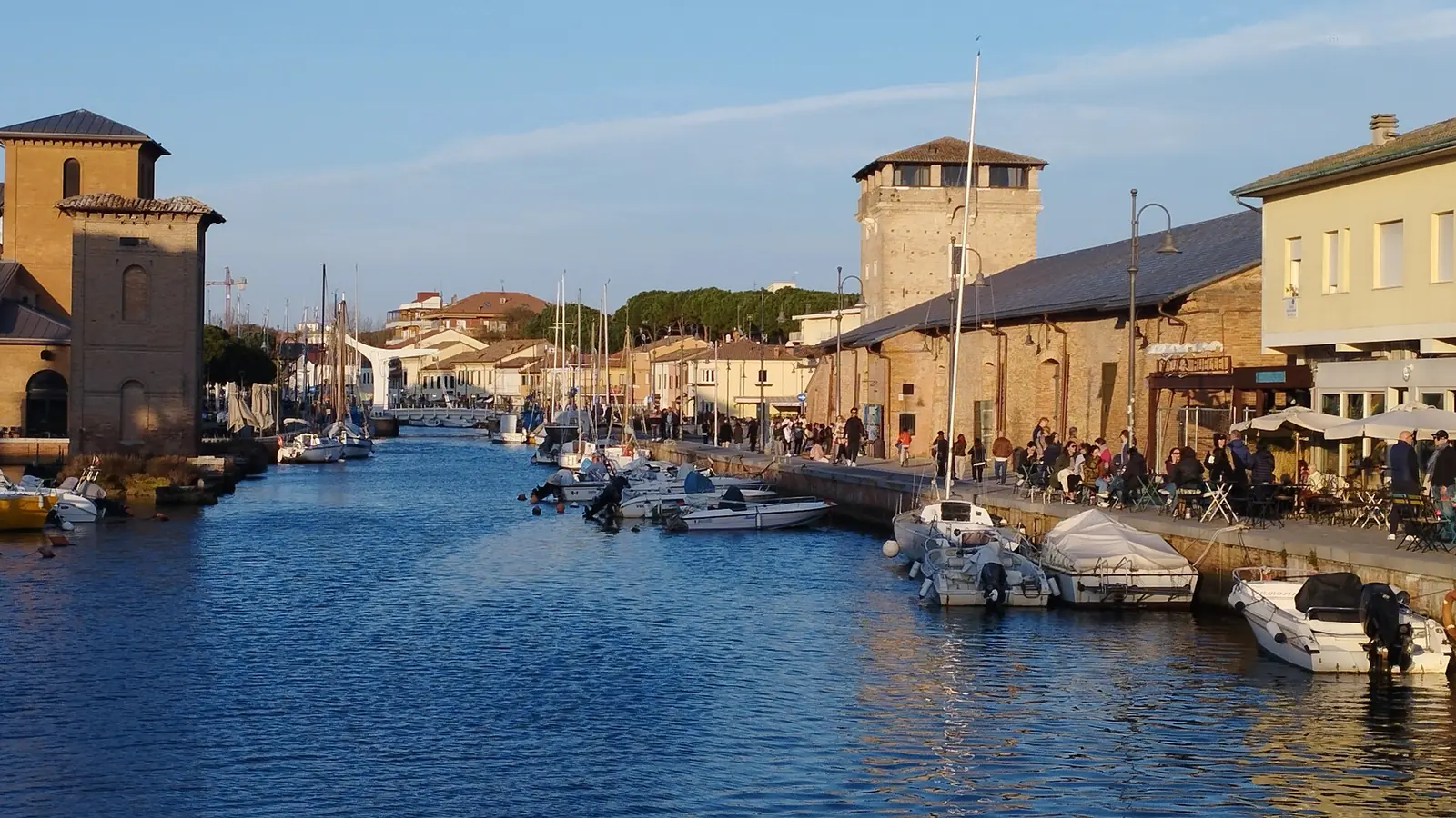 Cervia canal harbour with the two Magazzini del Sale on its banks and boats moored in the water