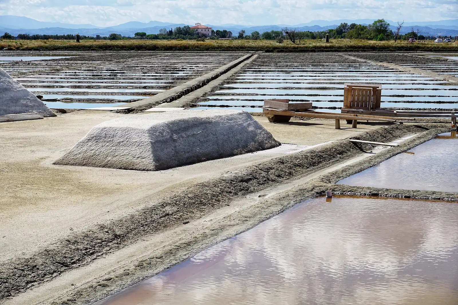 Un cumulo di sale e le vasche della salina Camillone di Cervia, con le colline sullo sfondo