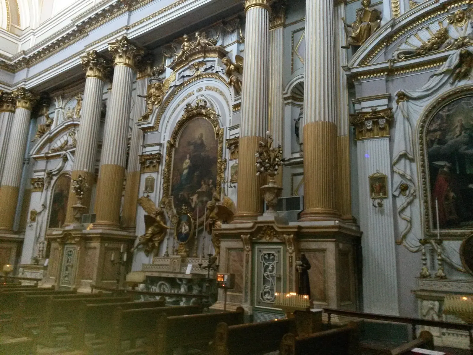 Die Seitenaltäre der Chiesa di Santa Maria dei Servi in Rimini mit Altarbildern, goldenen Engeln und kannelierten Säulen