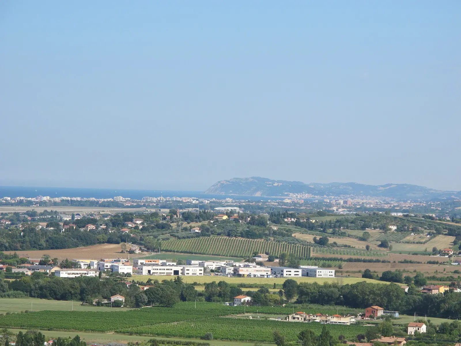 La costa riminese vista dal colle di Covignano, con la pianura coltivata, il mare e il promontorio di Gabicce