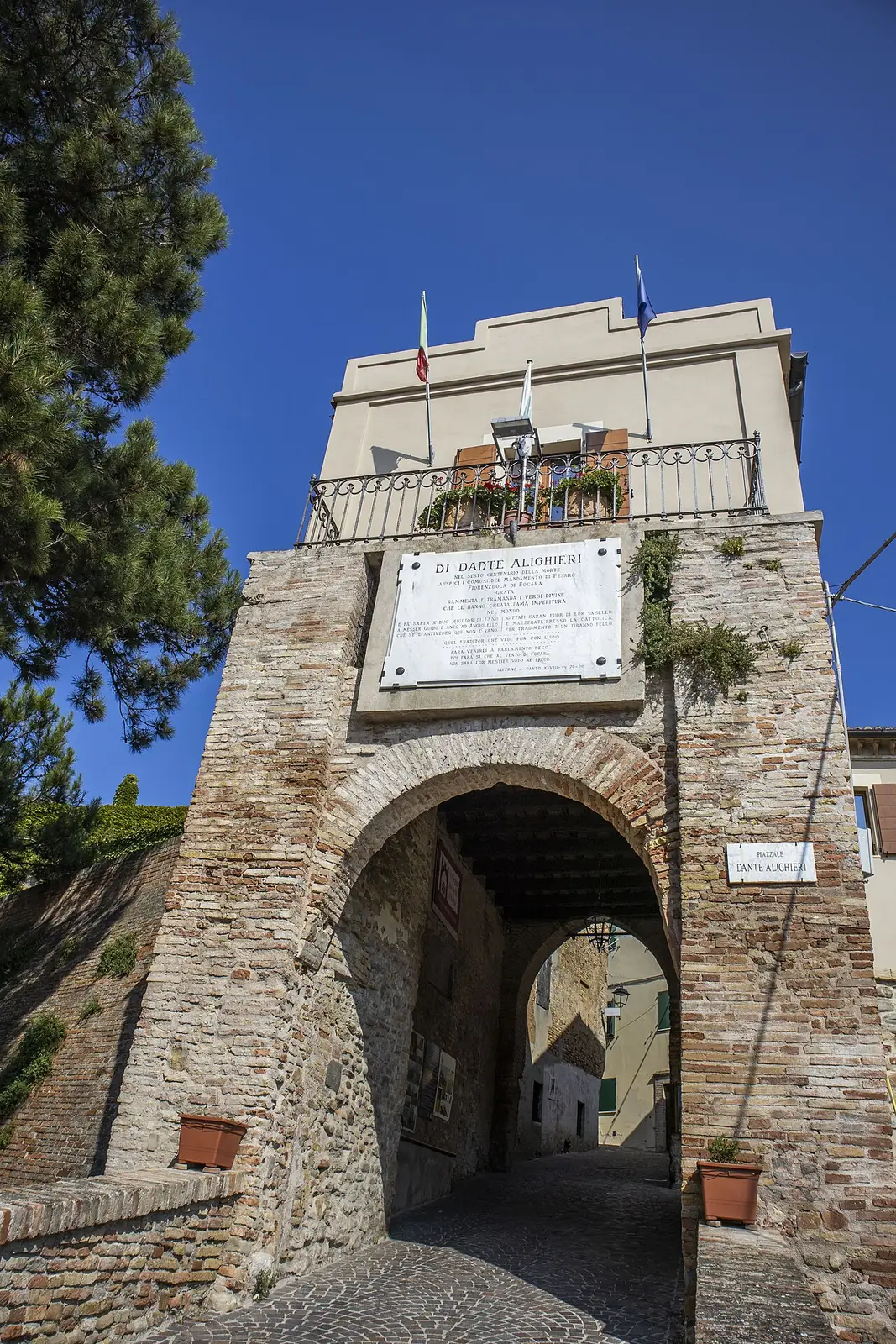 La porta del borgo di Fiorenzuola di Focara, un arco in laterizio sotto una lapide con il nome di Dante Alighieri