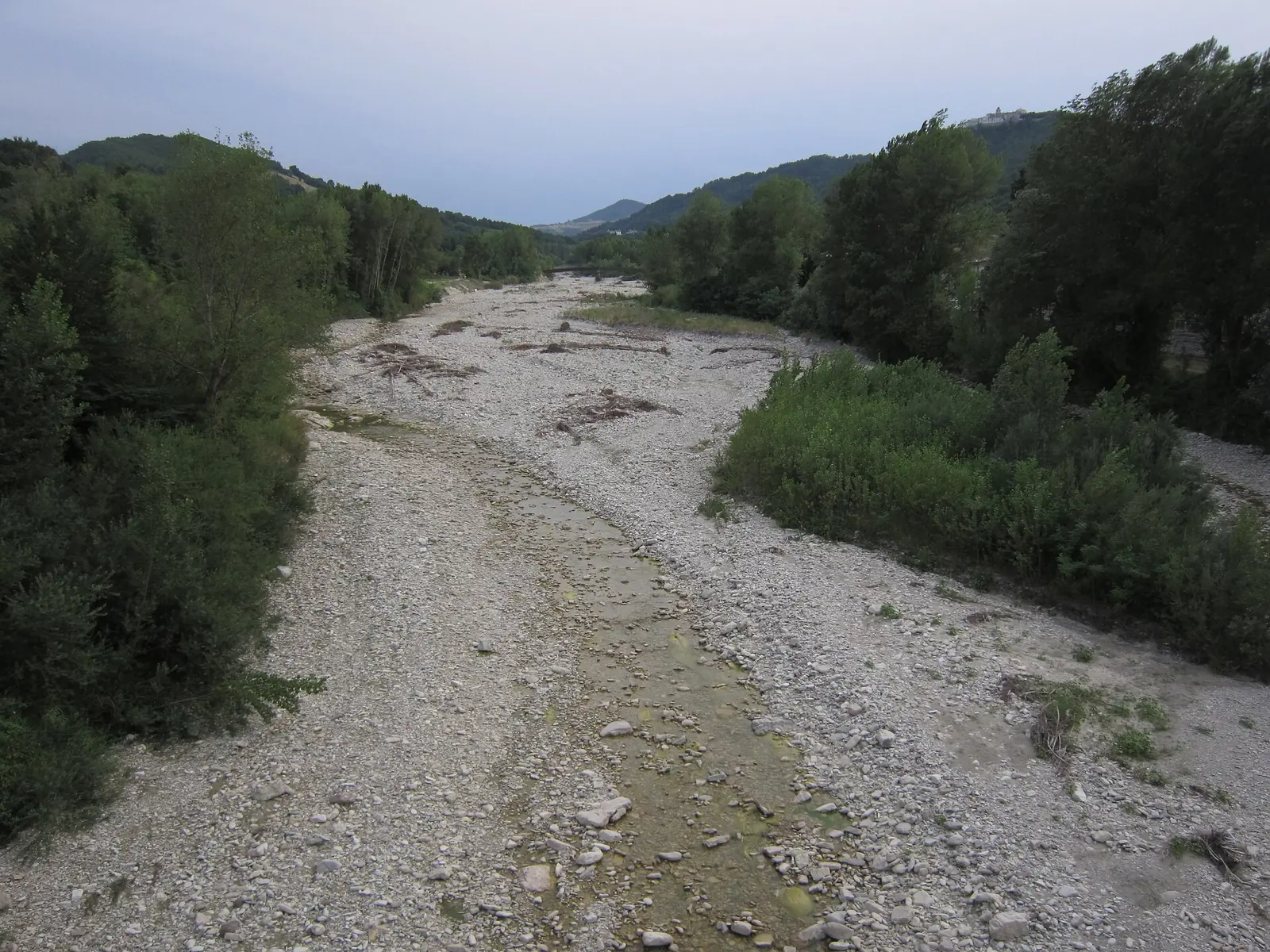 Il letto ghiaioso del fiume Conca fra le sponde boscose, ripreso a Mercatino Conca, nell'entroterra