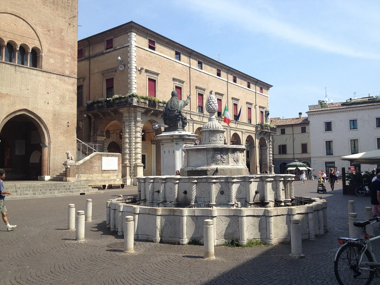 Fontana della Pigna in Piazza Cavour, Rimini, with the pope's statue behind and the square's historic palaces