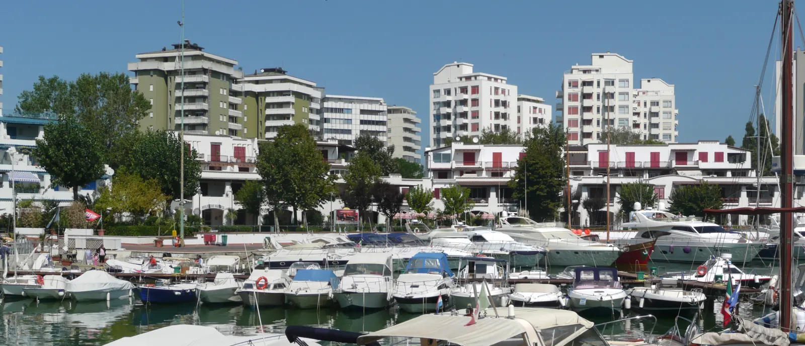 La darsena di Portoverde con barche a motore ormeggiate e i palazzi bianchi e verdi sul fondo