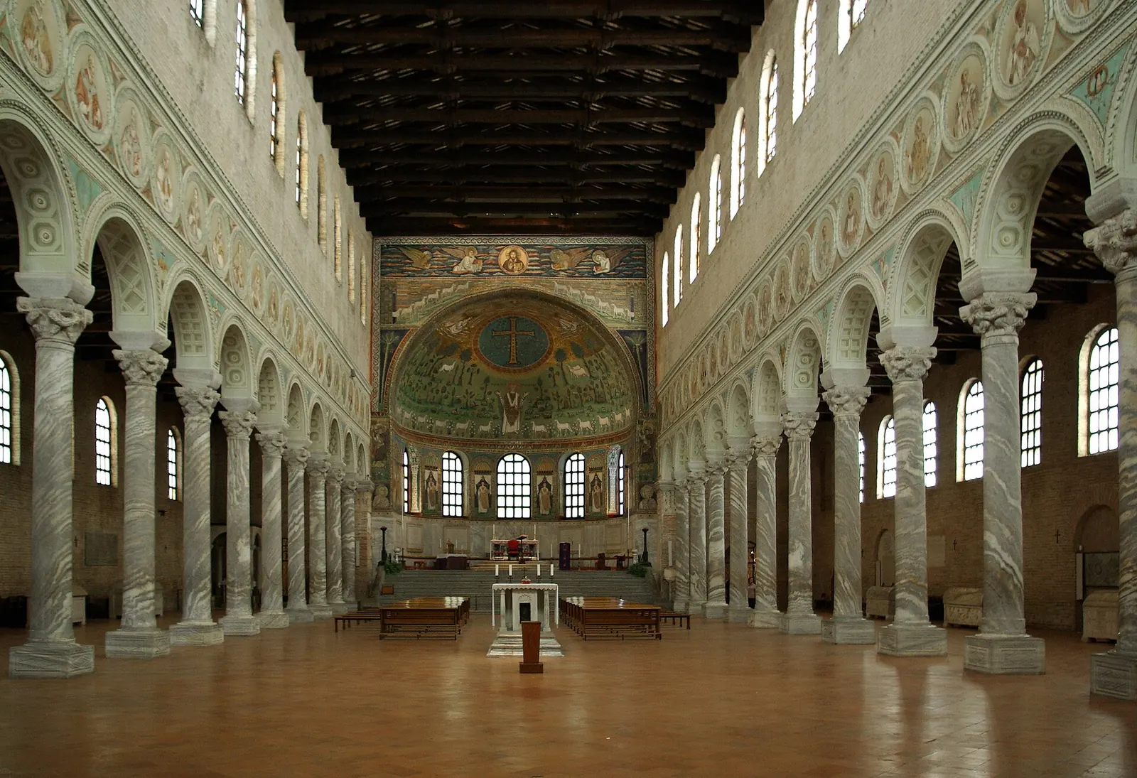 La navata della basilica di Sant'Apollinare in Classe a Ravenna, con le colonne di marmo e il mosaico dell'abside