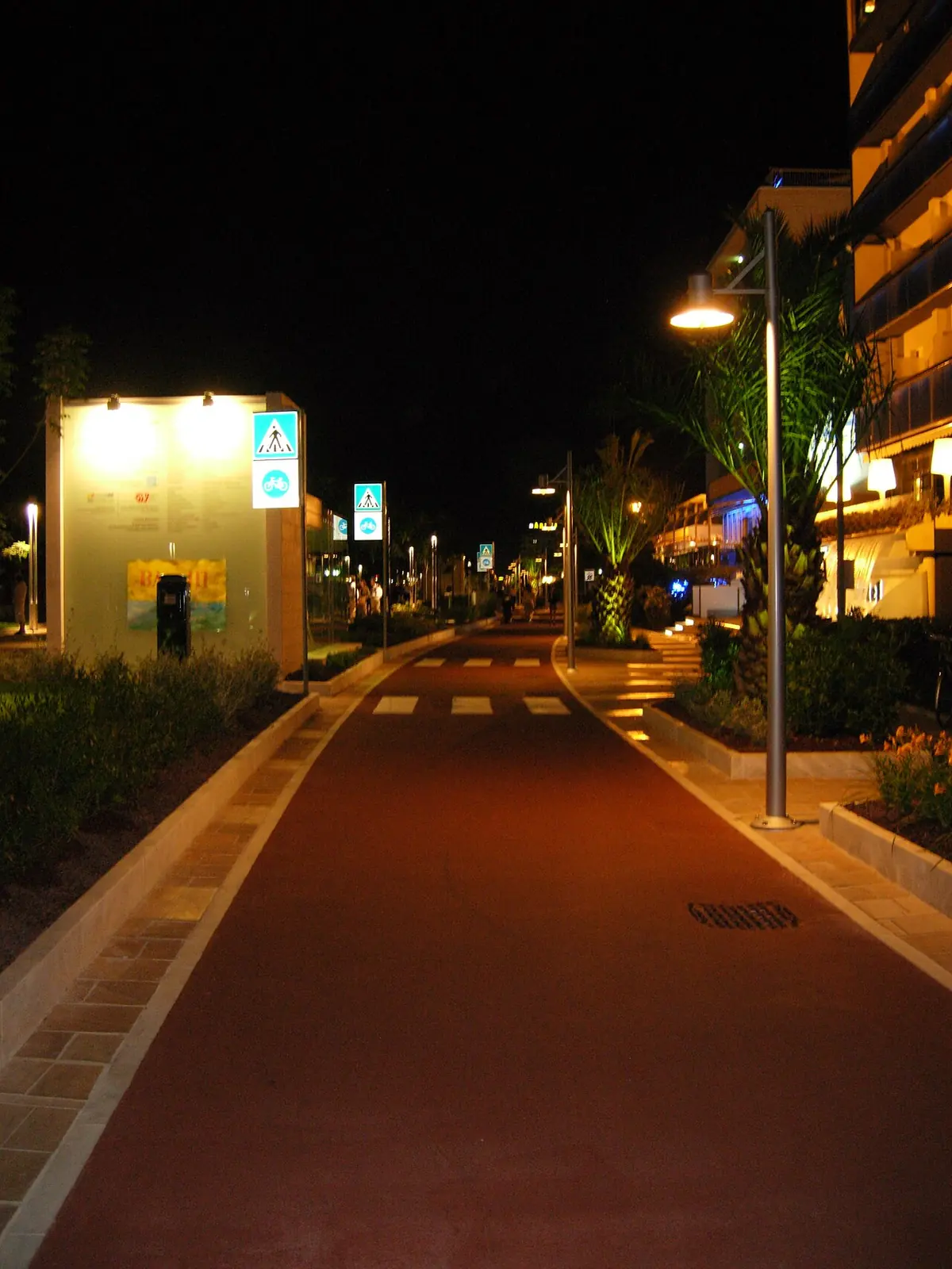 Le front de mer de Riccione le soir, avec la voie cyclable rouge près du parcours piéton et les lampadaires allumés
