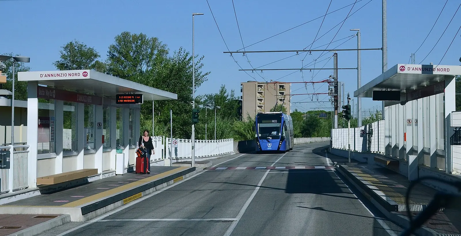 La fermata D'Annunzio Nord del Metromare a Riccione, con la corsia riservata e un filobus blu in arrivo