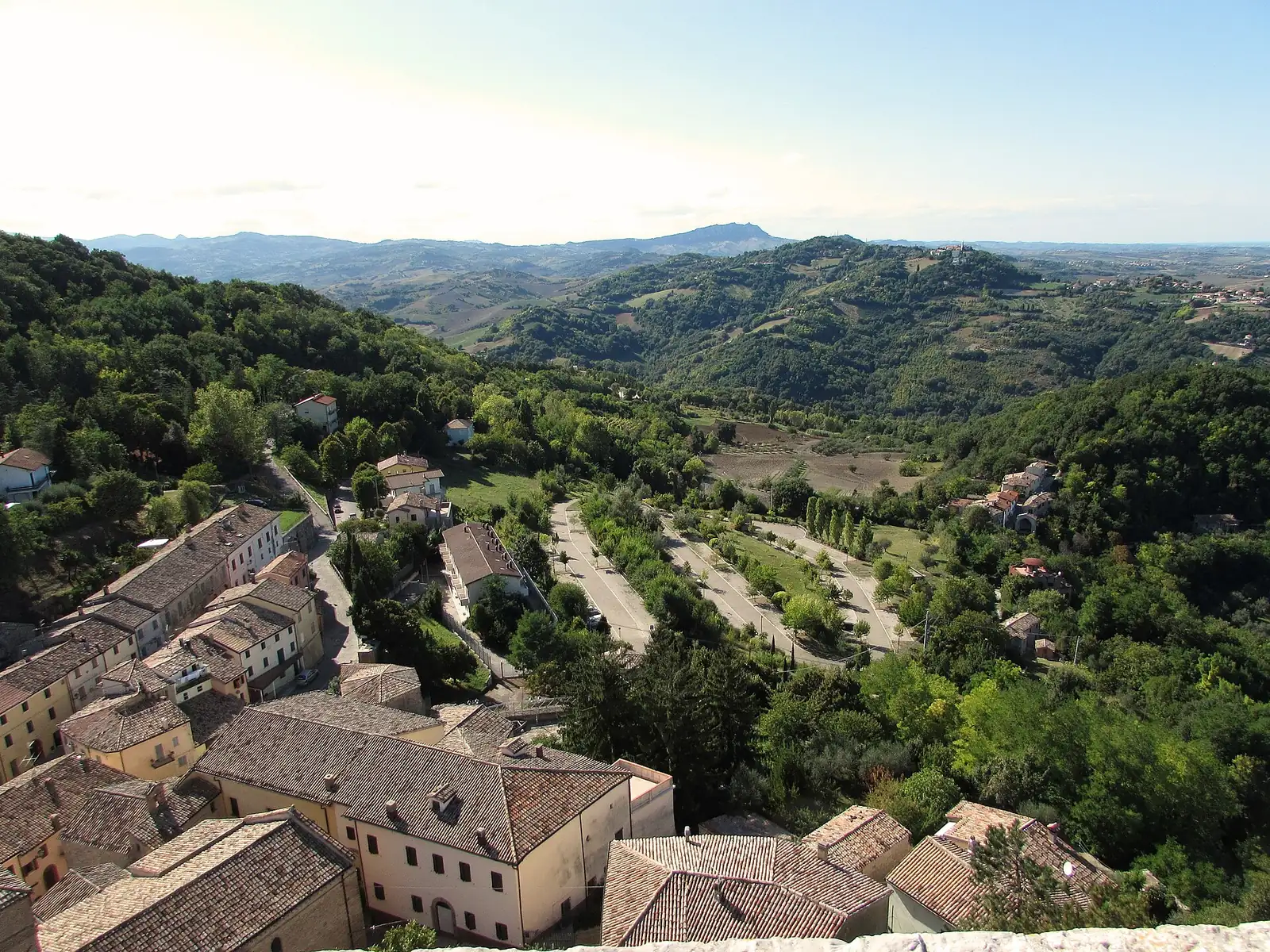Le colline della Valconca viste dalla rocca di Montefiore Conca, con i tetti del borgo in primo piano