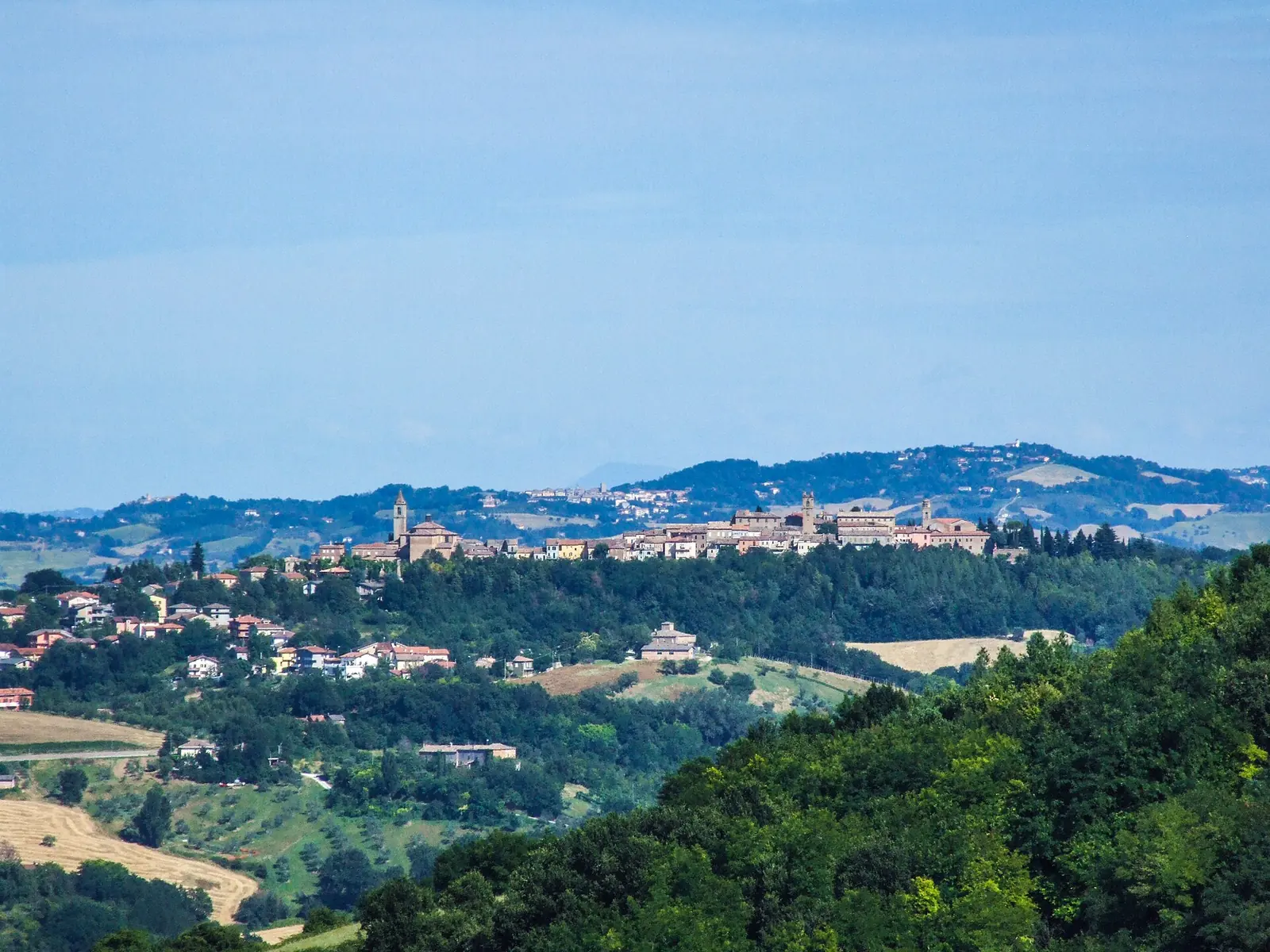 Saludecio sul crinale di una collina, fra boschi e campi della Valconca