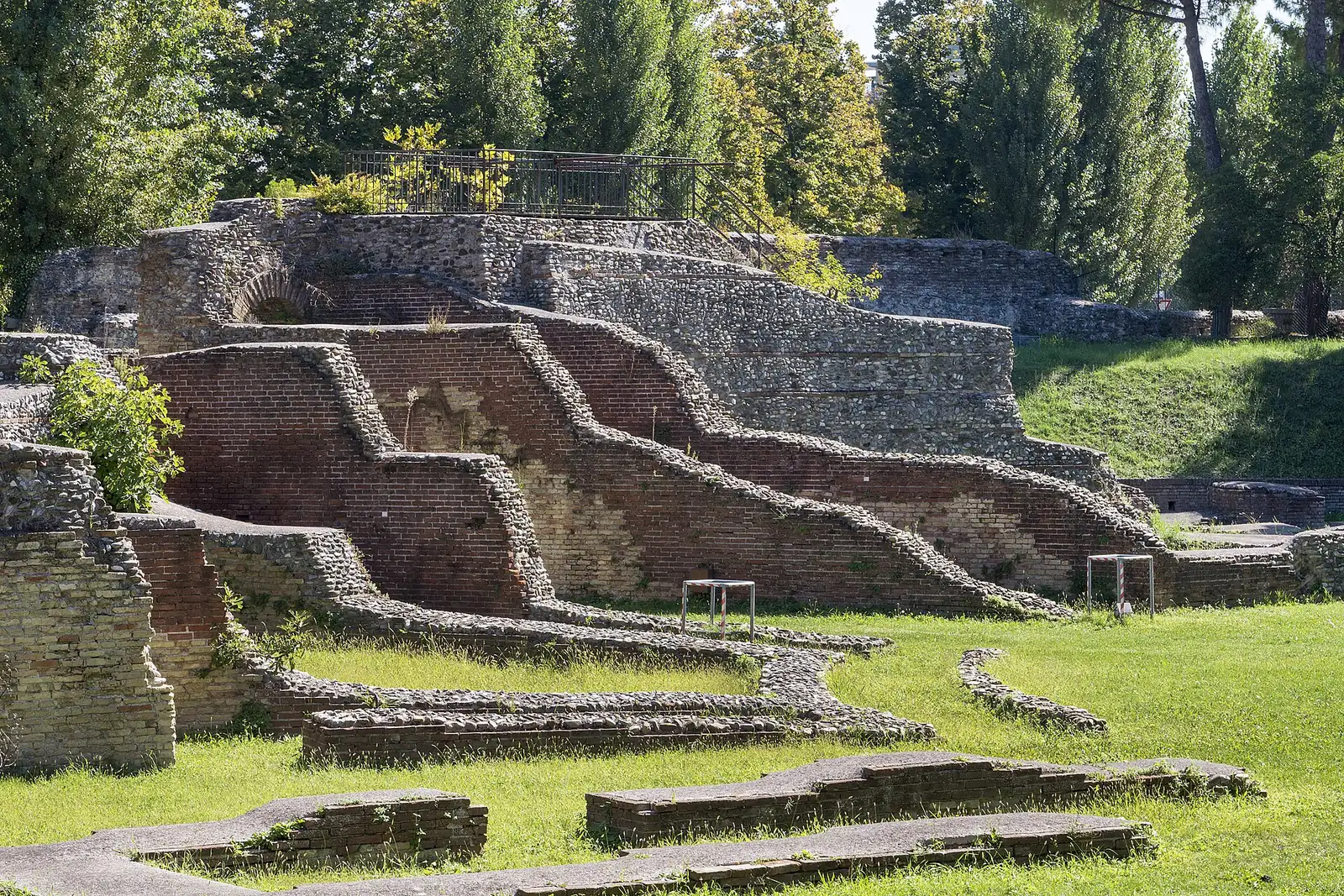 Les vestiges en brique et galets de l'amphithéâtre romain de Rimini, entre l'herbe et les arbres