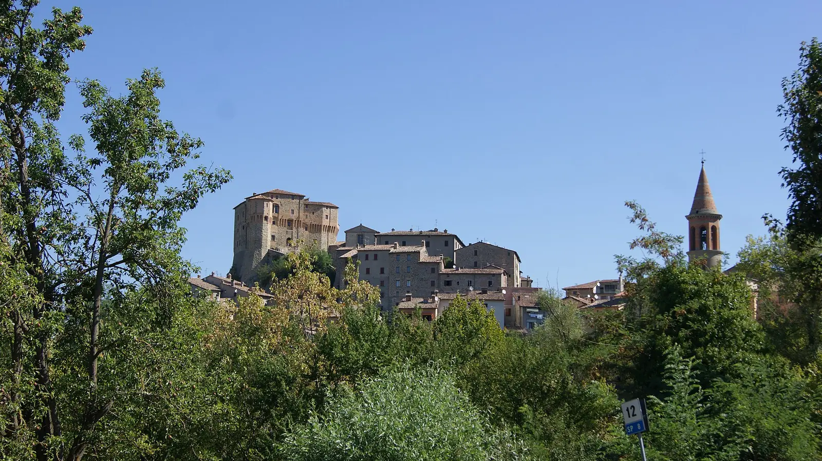 Sant'Agata Feltria vista dalla strada, con la Rocca Fregoso sopra le case e il campanile a destra