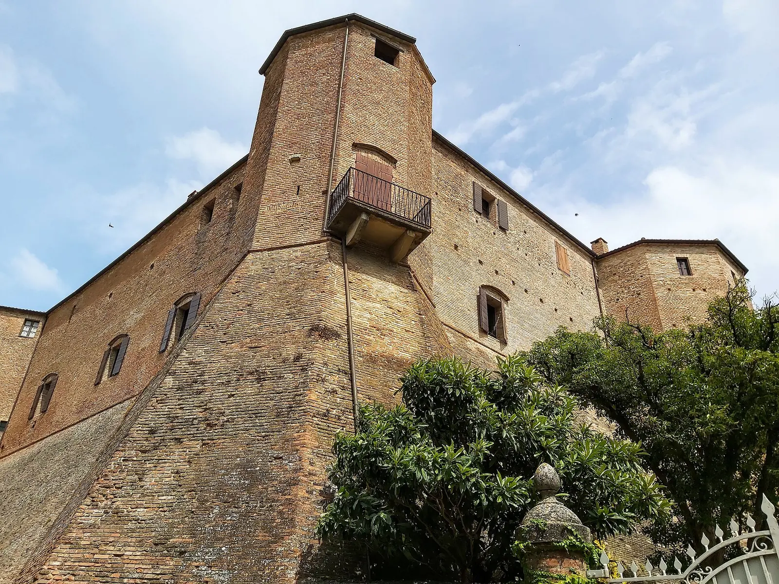 La torre poligonale e le mura a scarpa in mattoni della Rocca Malatestiana di Santarcangelo, viste dal basso
