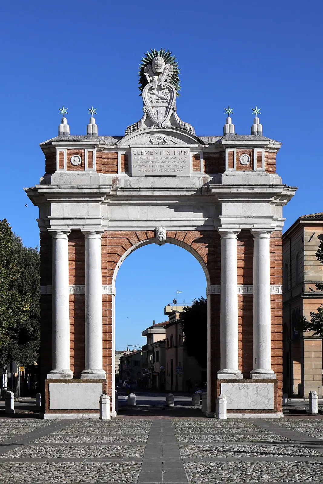 Der Arco Ganganelli in Santarcangelo di Romagna aus Backstein und weißem Stein mit vier Säulen und dem päpstlichen Wappen oben