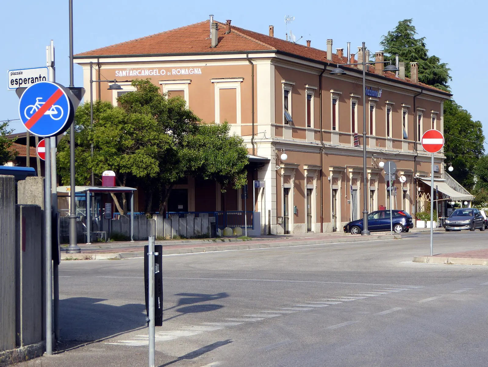 Der Bahnhof Santarcangelo di Romagna, ein zweigeschossiges terrakottafarbenes Gebäude, vom Vorplatz aus gesehen