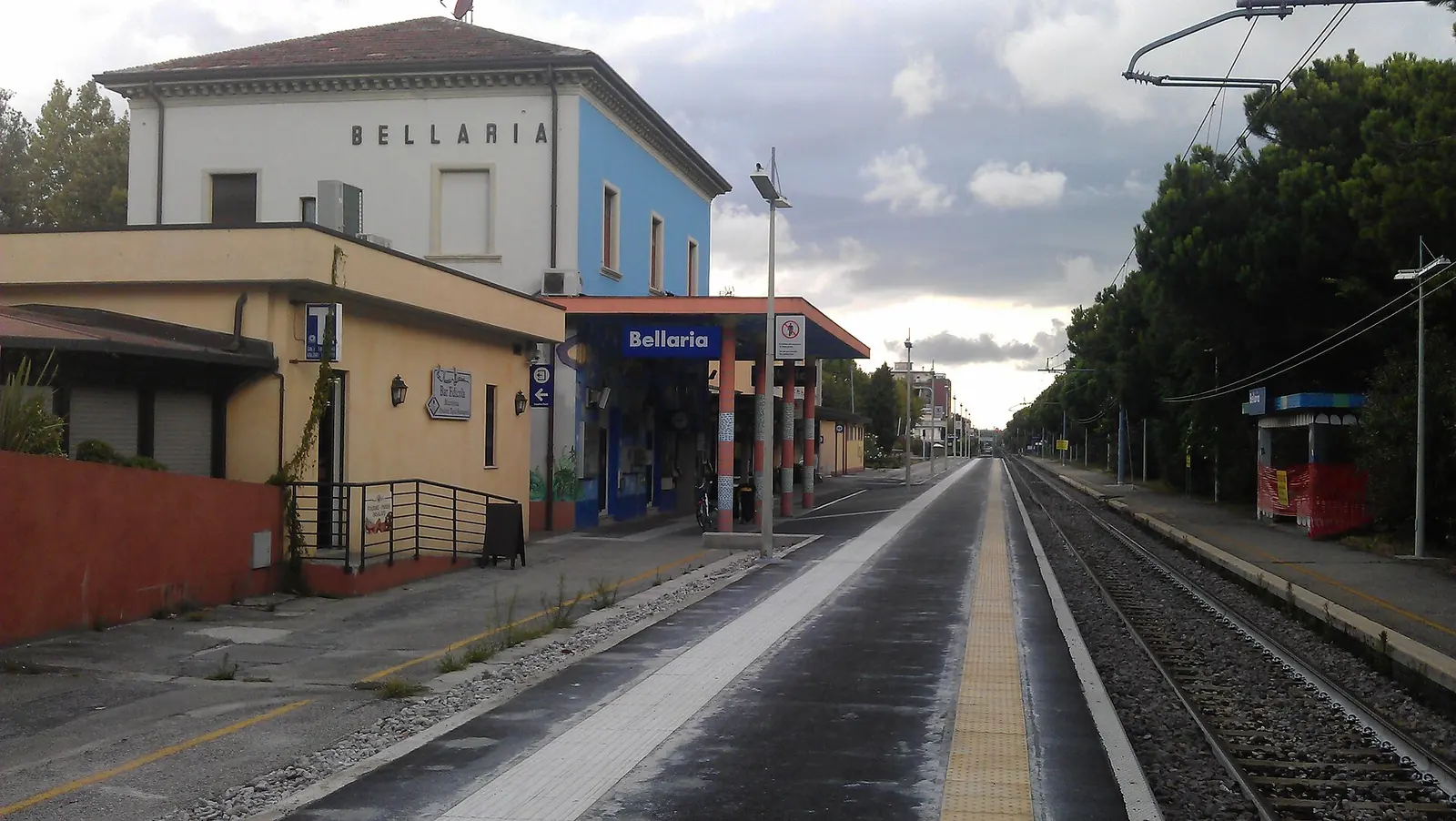 Bellaria railway station building, with its white and blue façade, canopy and tracks