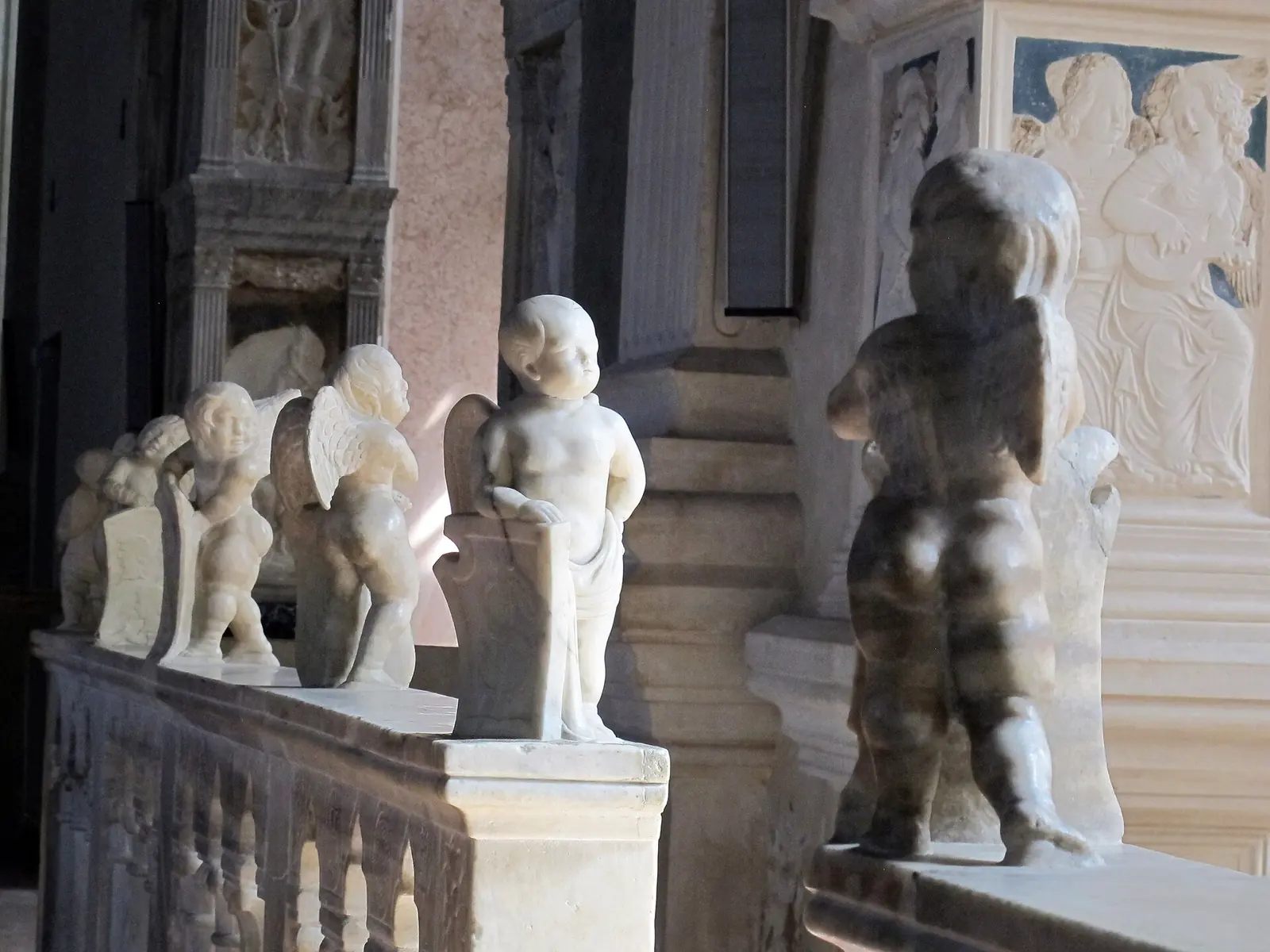 Marmorputten auf der Balustrade der Cappella degli Angeli im Tempio Malatestiano in Rimini mit Reliefs musizierender Engel