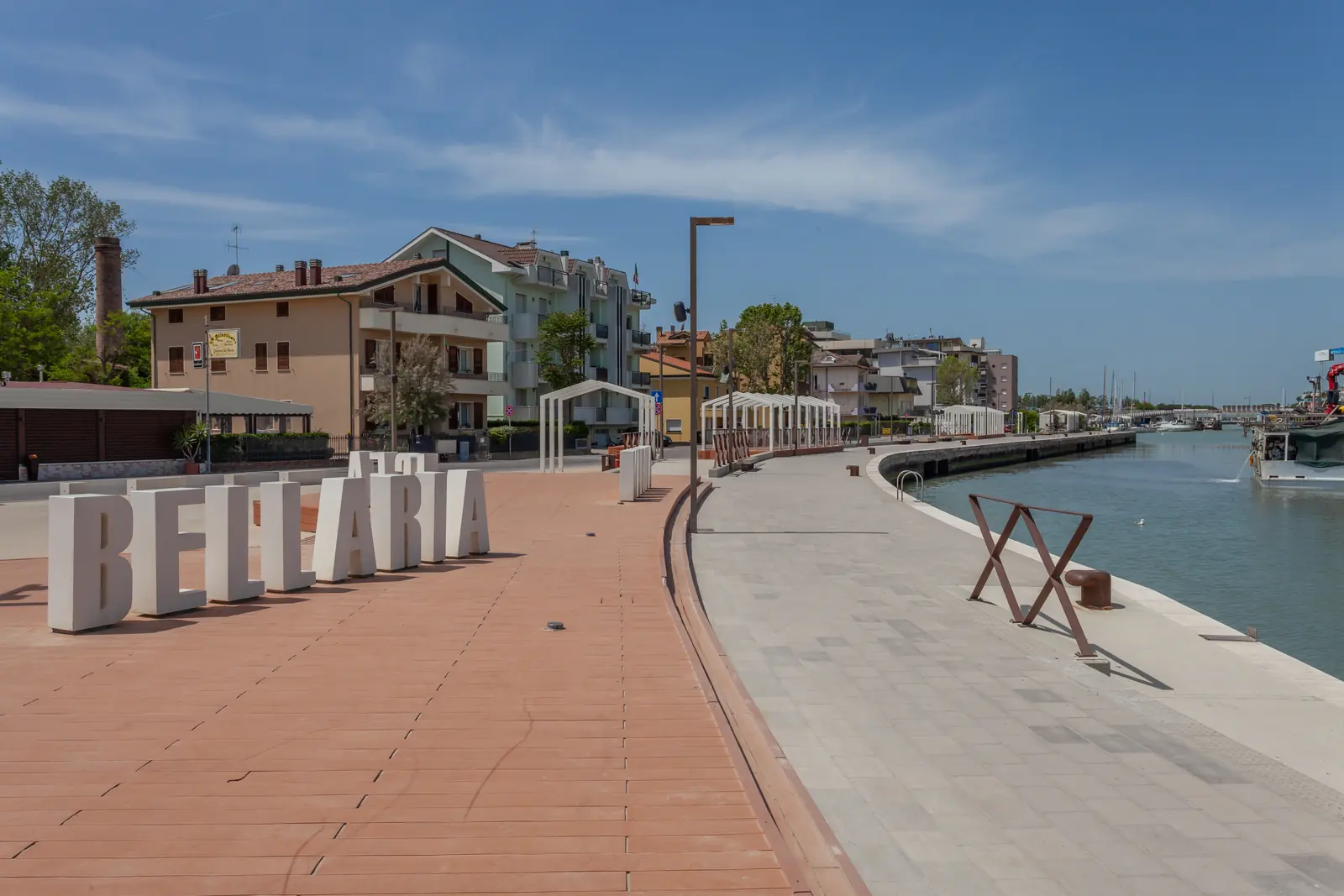 La passeggiata lungo il porto canale di Bellaria, con le grandi lettere bianche del nome e le case sulla riva