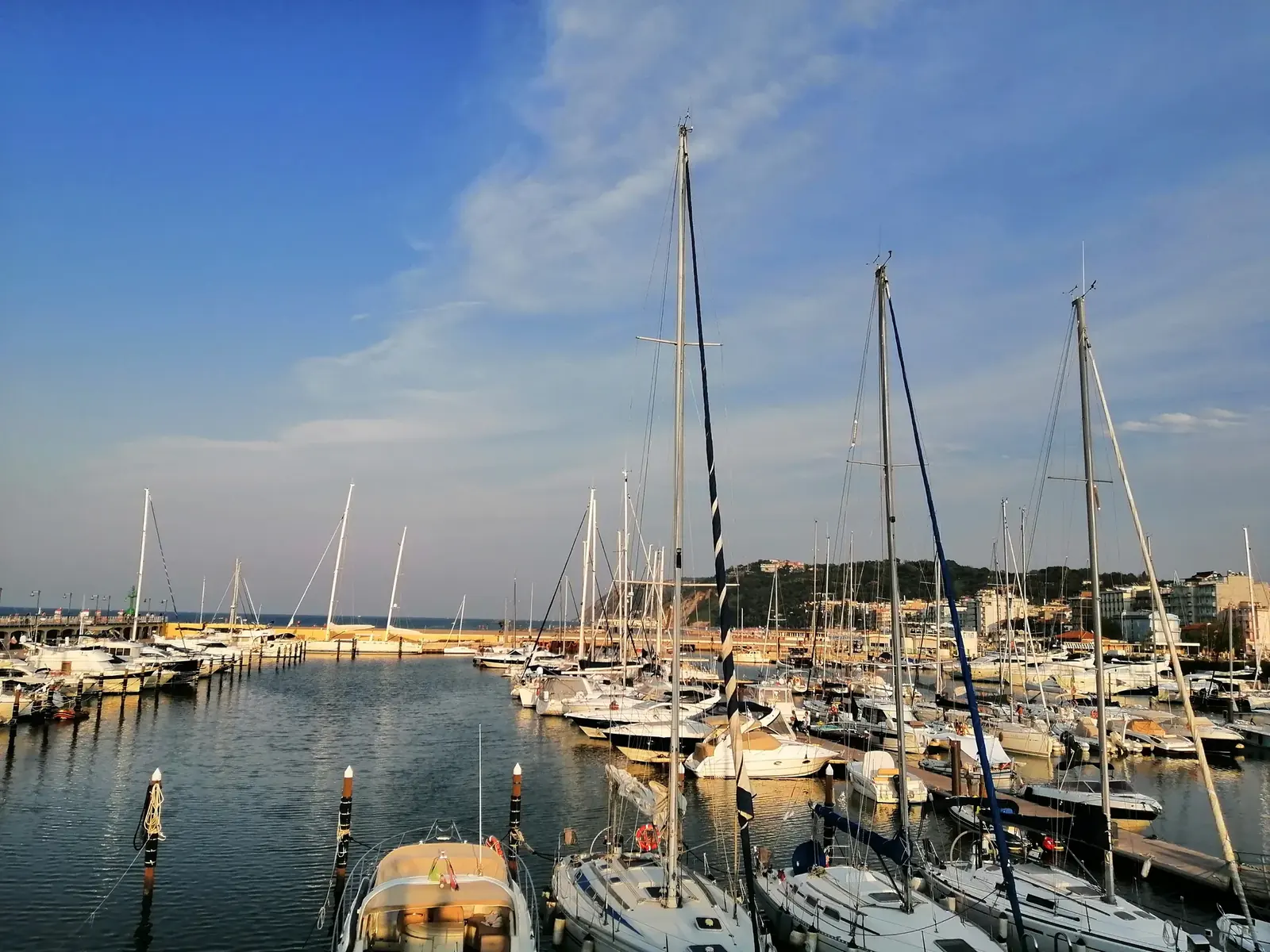 Le barche a vela ormeggiate nella darsena di Cattolica, con le colline di Gabicce sullo sfondo
