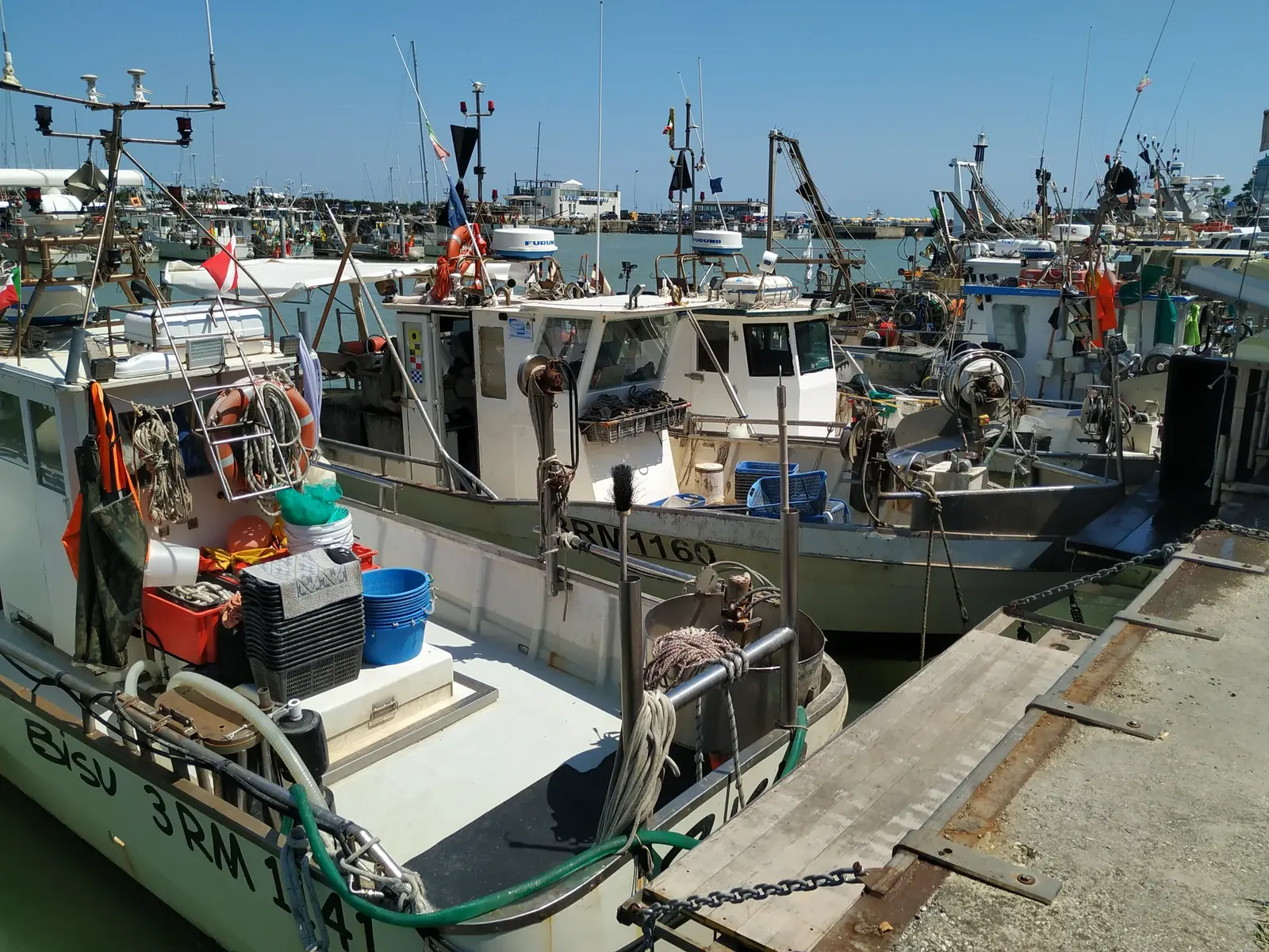 Pescherecci ormeggiati alla banchina del porto di Cattolica, con le reti e le casse sul ponte