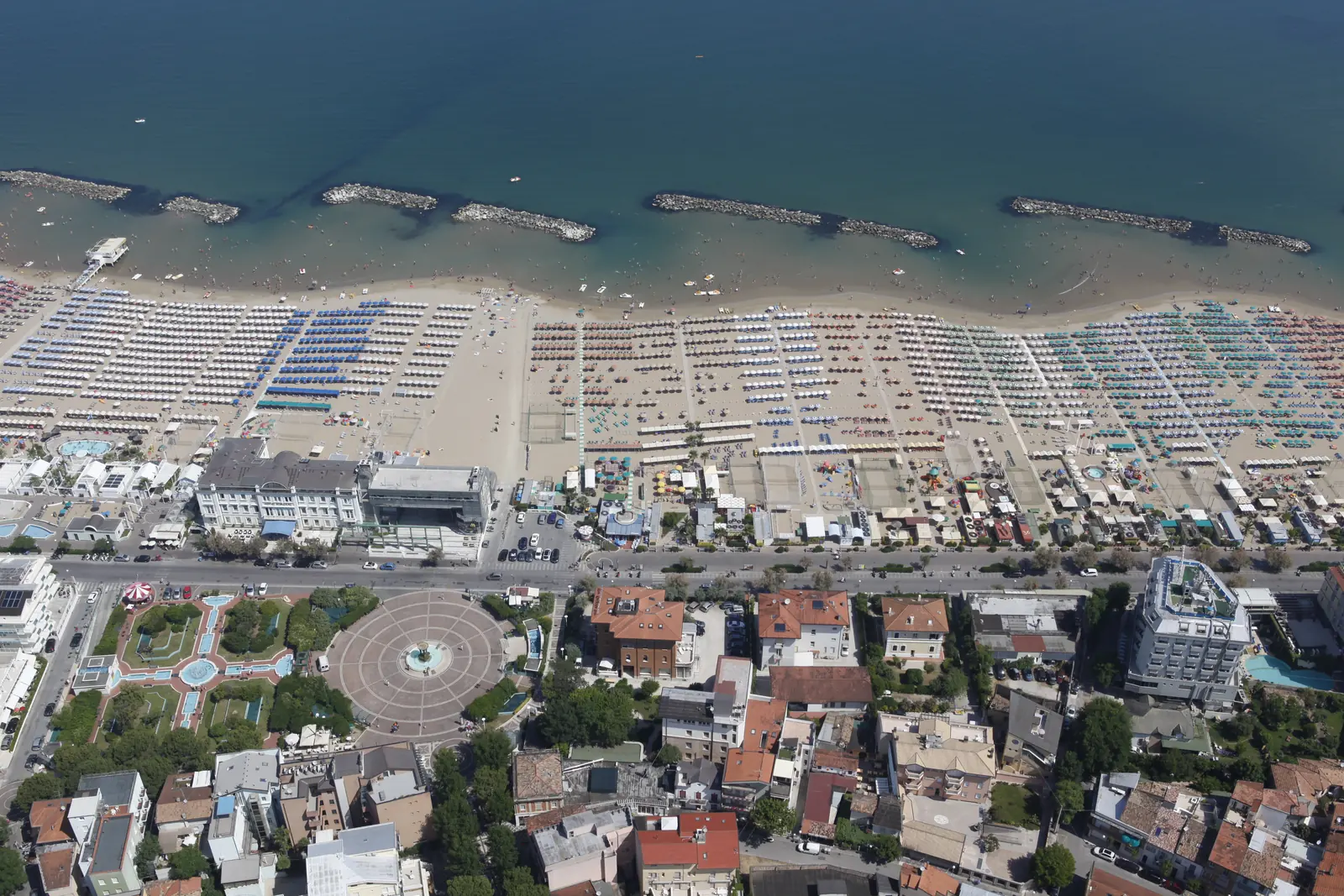 Cattolica dall'alto, con piazza Primo Maggio e i giardini, la spiaggia con gli ombrelloni e le scogliere