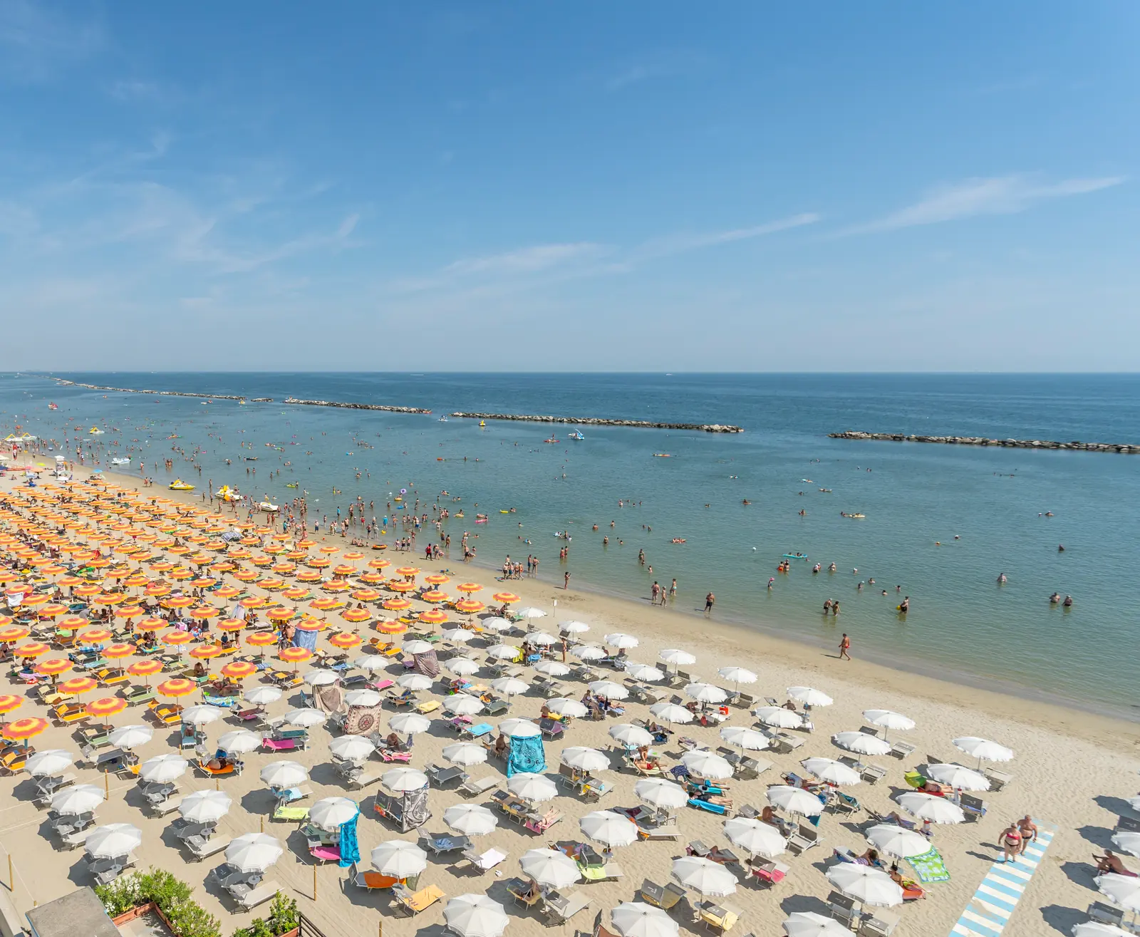 La spiaggia di Cesenatico vista dall'alto, con le file di ombrelloni arancioni e bianchi e il mare