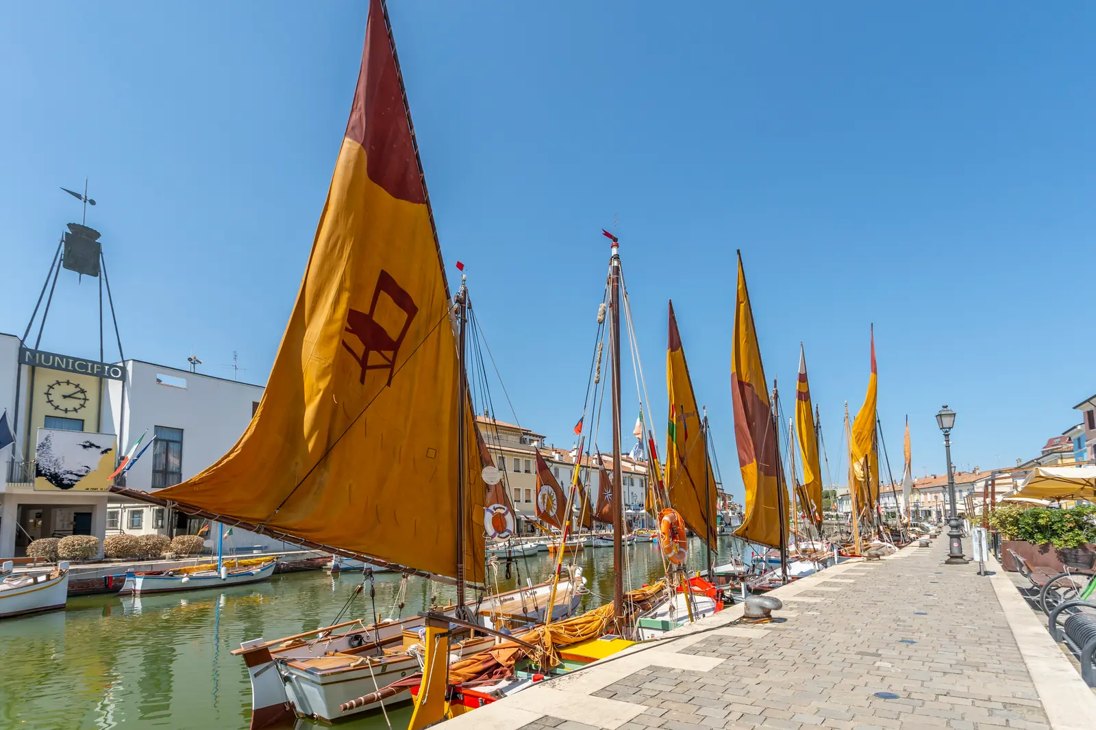 Le vele colorate delle barche storiche lungo la banchina del porto canale di Cesenatico, accanto al municipio
