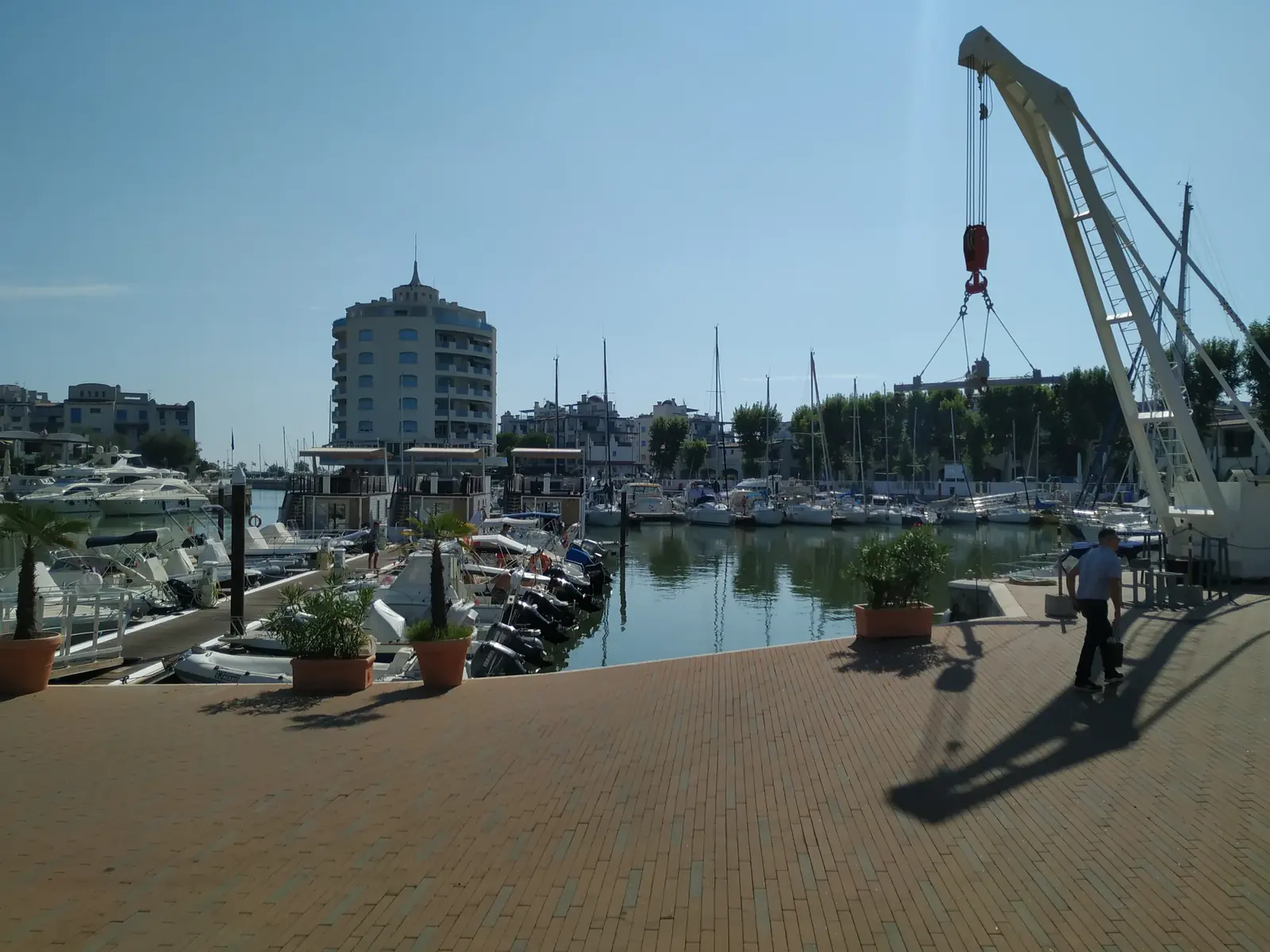La banchina in cotto della darsena di Portoverde, con la gru per le barche e il palazzo rotondo sullo sfondo