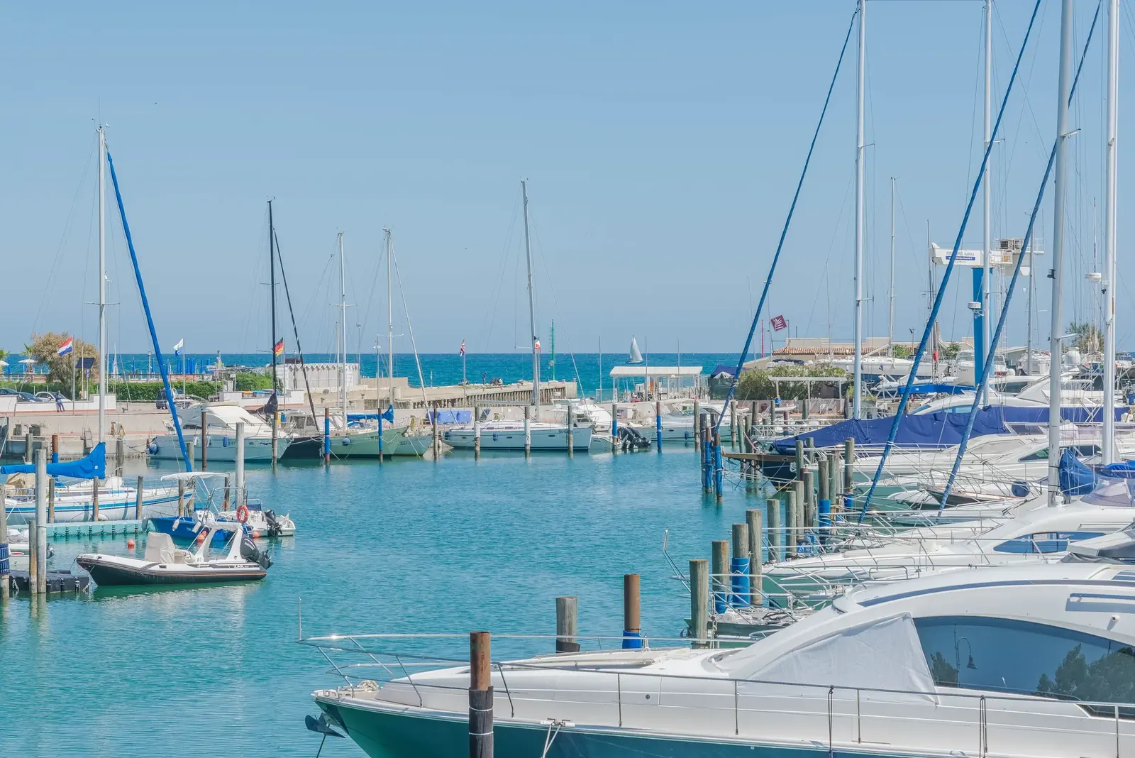 La darsena di Portoverde con le barche a vela e i motoscafi ormeggiati ai pontili, sotto il cielo terso