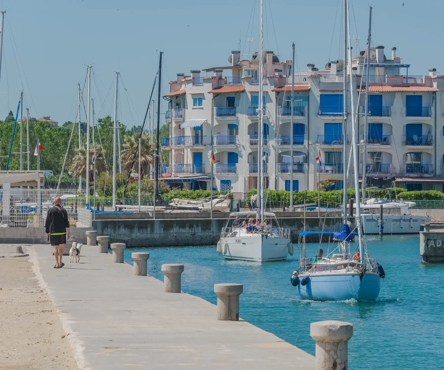 La darsena di Portoverde a Misano Adriatico, con le barche a vela, il molo e le case bianche e azzurre sull'acqua