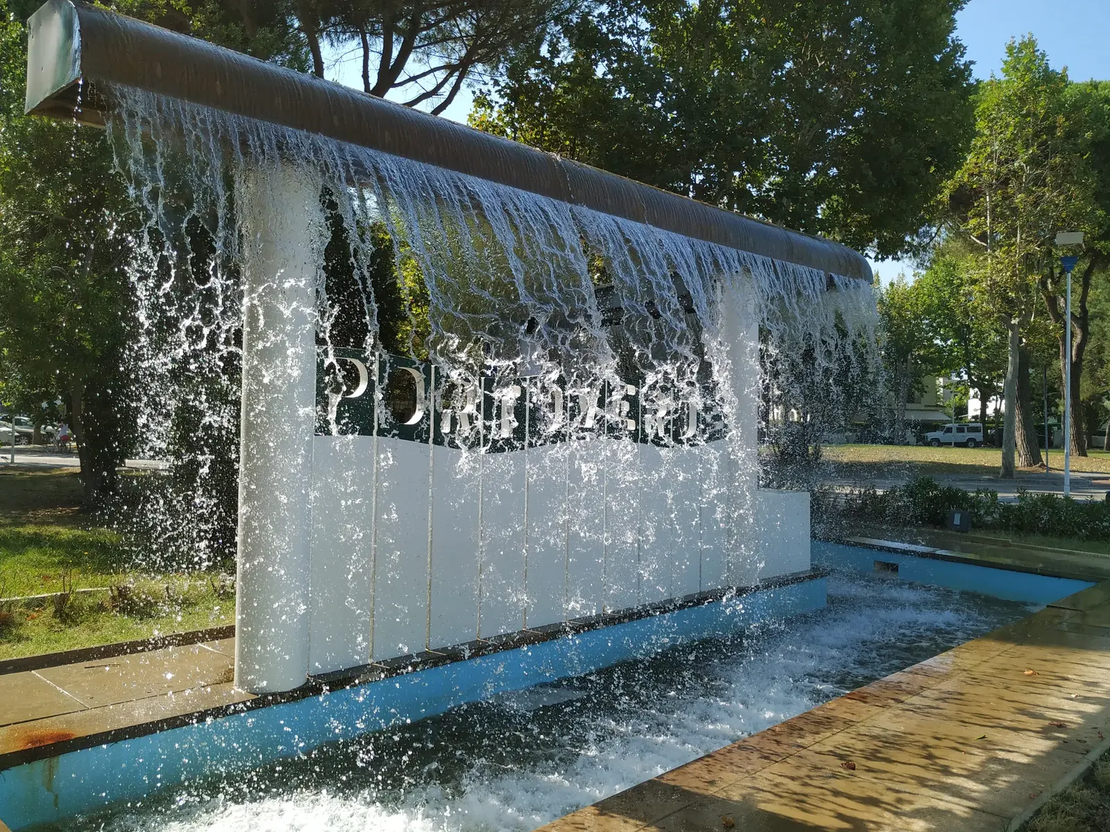 La fontana a cascata all'ingresso di Portoverde, con l'acqua che ricade davanti al muro bianco