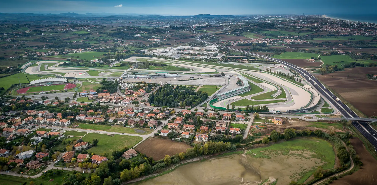 Il Misano World Circuit dall'alto, con il paese, i campi e la costa sullo sfondo