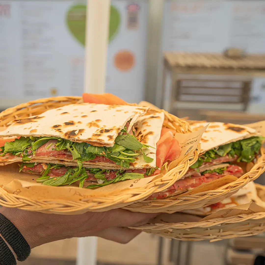Una piadina farcita con prosciutto crudo e rucola, servita in un cestino di vimini