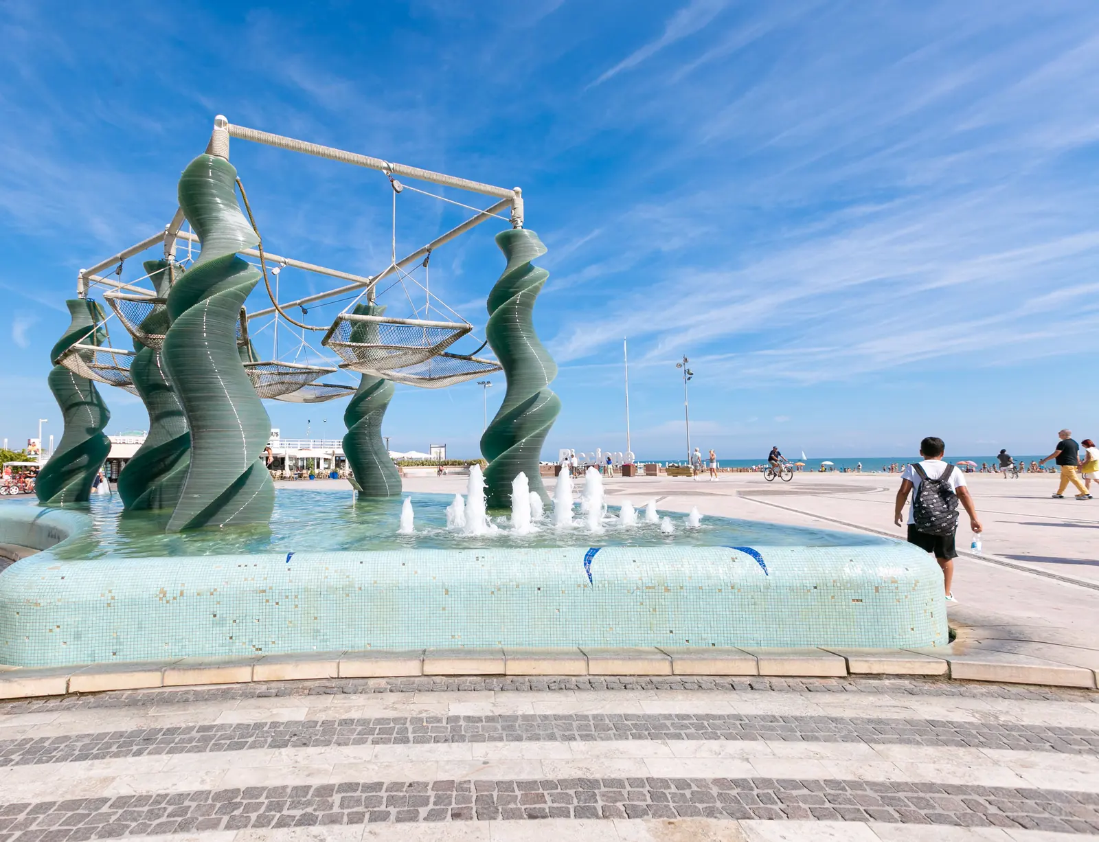 La fontana di piazzale Roma a Riccione con le colonne verdi a spirale e le reti sospese, davanti al mare