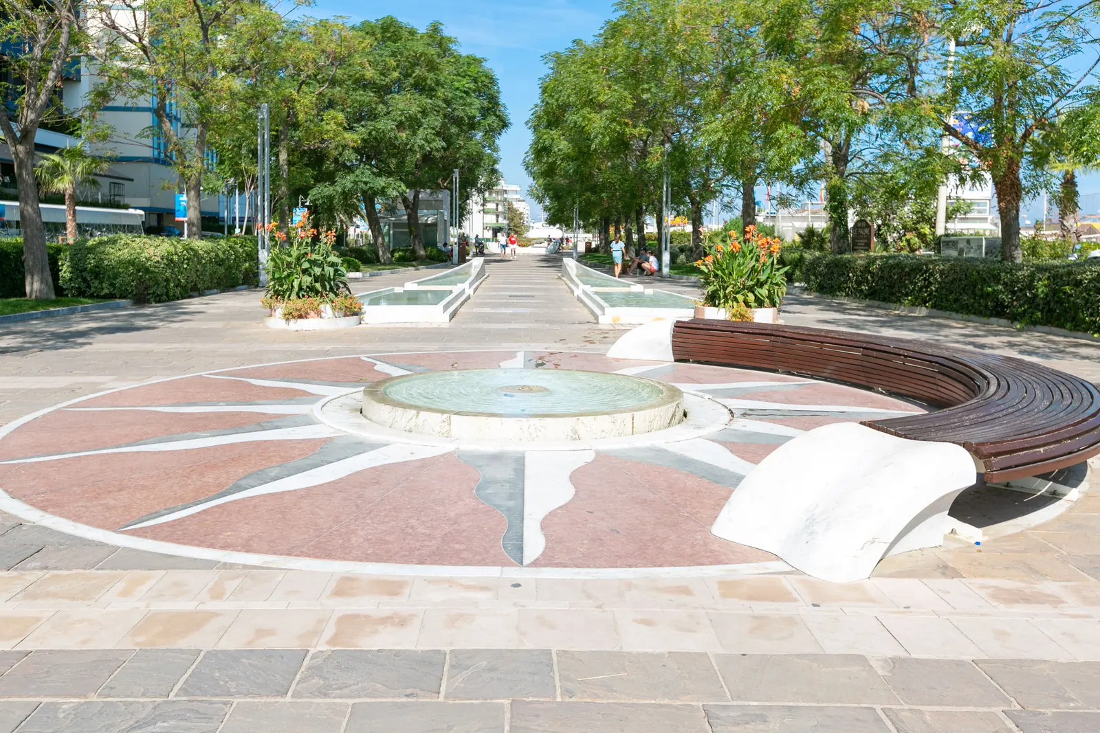 La rosa dei venti in marmo colorato con una fontanella al centro e una panca curva di legno, sul lungomare di Riccione