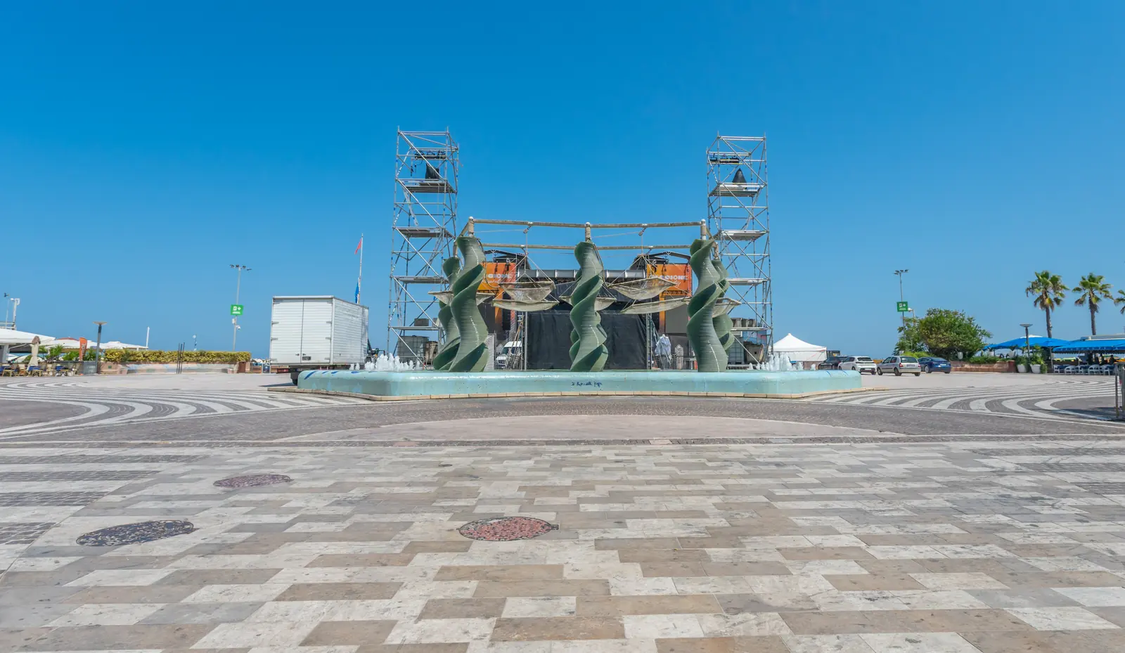 La fontana di piazzale Roma a Riccione con le colonne verdi a spirale, davanti al palco allestito per i concerti